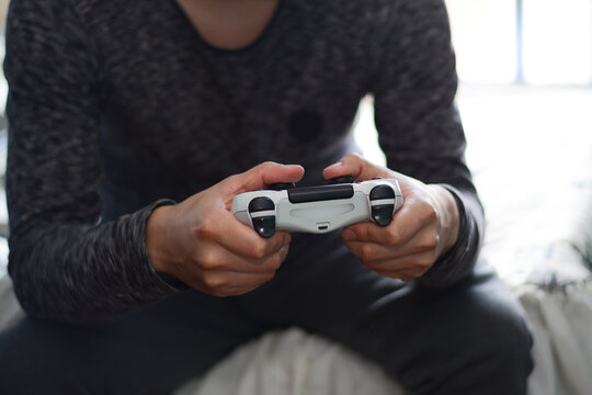 A man holding a game controller. A young man playing video games,