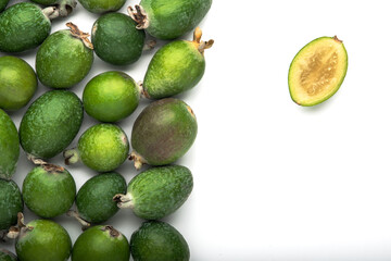 Green, whole and cut feijoa fruits on an isolated white background, with space for text.