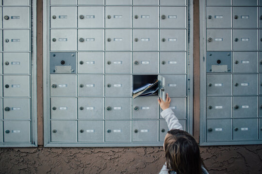 Child unlocks and opens door to cluster mailbox unit