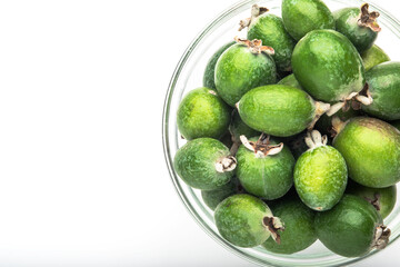 Green feijoa fruit in a glass dish, isolated on a white background. Tropical feijoa fruit. Set of ripe feijoa fruits. the view from the top. Space for copying. Organic food. Vegetarian food. Food stoc