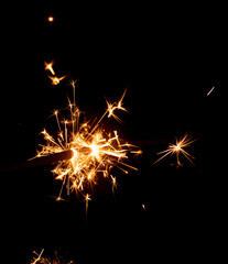 Burning sparkler against black background