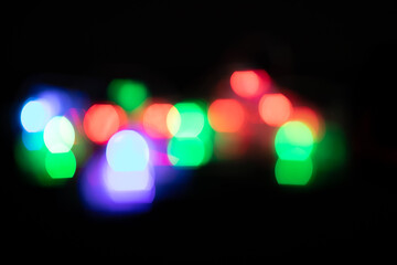 Multicolored spots of light against black background