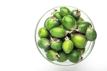 Green feijoa fruit in a glass dish, isolated on a white background. Tropical feijoa fruit. Set of ripe feijoa fruits. the view from the top. Space for copying. Organic food. Vegetarian food. Food stoc