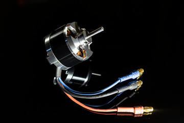 Aircraft model brushless (BLDC) outrunner 3-phase motor on a black background. Selective soft focus.