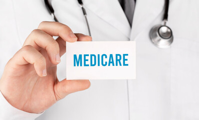 Doctor holding a card with text Medicare, medical concept