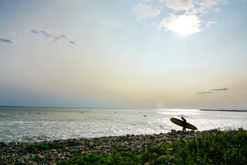 Silhouette of surfer at pretty ocean sunset.