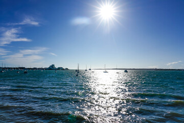 Bright sun over scenic blue harbor.