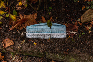 Dirty blue Corona face mask carelessly thrown away