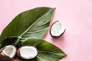 Obraz na płótnie Canvas coconut halves and tropical leaves