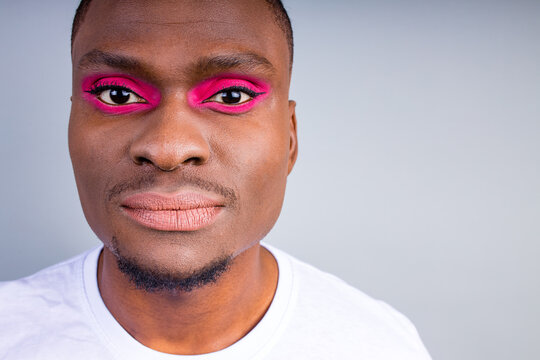 afro american man in white t-shirt casual style with pink eyeshadow and lipstick crossdressing in fashion show studio background