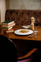 Caesar salad with croutons, quail eggs, cherry tomatoes and grilled chicken in wooden table