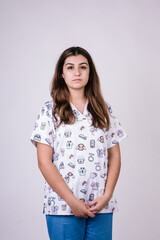 Obraz premium portrait of a female nurse looking serious. She is wearing a very colorful figure uniform. Her hair is brown and long