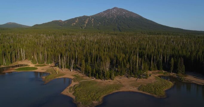 Wide aerial, lake surrounded by woods in Oregon