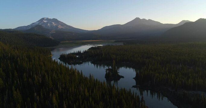 Wide aerial, river flows near Mt. Bachelor at sunset
