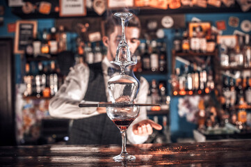Barman concocts a cocktail at the bar