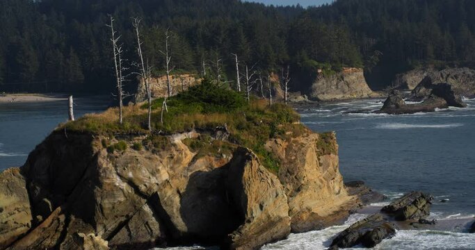Wide aerial, small rocky island off Oregon coast