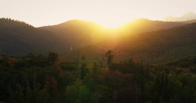 Wide aerial, sunset over autumn foliage in Utah