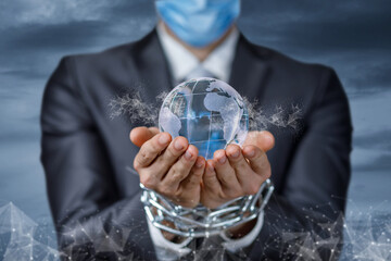 A businessman in a mask with chains on his hands shows the Globe .
