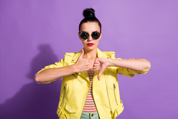 Photo of young serious beautiful girl woman female showing thumb up and thumb down isolated on violet color background