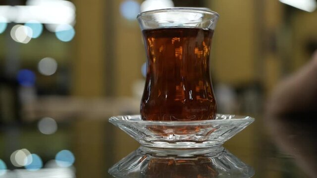 turkish glass of black tea on bokeh background