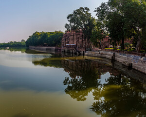 Fototapeta na wymiar Reflections and serenity along the southern shore of Gajner lake in Rajasthan, India