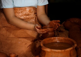 Pottery workshop. A little girl makes a vase of clay. 