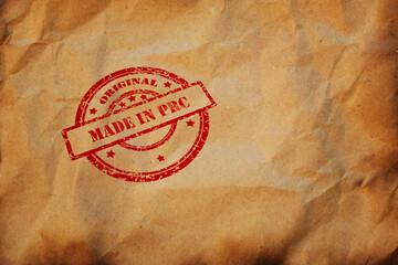 Made in PRC stamp printed on crumpled sheet of burnt paper. PRC Product Business, parcel, package,...