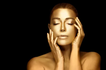 Goldhautfrau. Schönes vorbildliches Mädchen mit glühendem Goldkörpermake-up © Casther