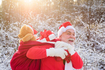 Santa grandfather deliver gifts. Santa Claus in Christmas suits in snowy winter mountain. New Year and xmas is coming.