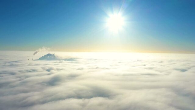 shining sun and clear blue sky while flying above the overcast clouds
