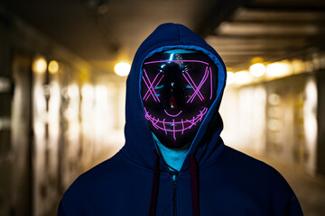 neon masked criminal on the dark. Selective focus
