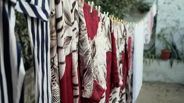 row of flags on the roof colorful  dresses on a rope with the wind sways slowly slow motion