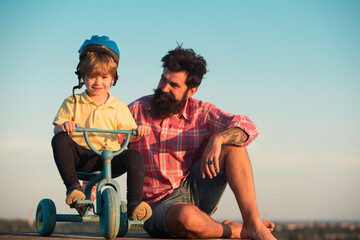 Lovely father teaching son riding bike. Fatherhood kids caring as dad and children family. Husband...