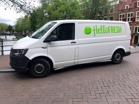 Amsterdam, the Netherlands - July 15, 2019: White Transporter HelloFresh delivery van parked by the side of the road. Nobody in the vehicle.