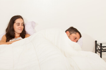 young angry couple not talking to each other in bed with problems