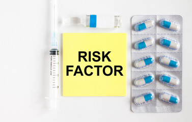 Yellow sticker with text Risk Factor on a white background with syringes, pills and ampoule