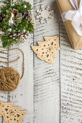 Frame top view mock up Christmas gift box with white ribbon, pine cones and wooden herringbone decoration. Flat lay on white wooden textured background with copy space