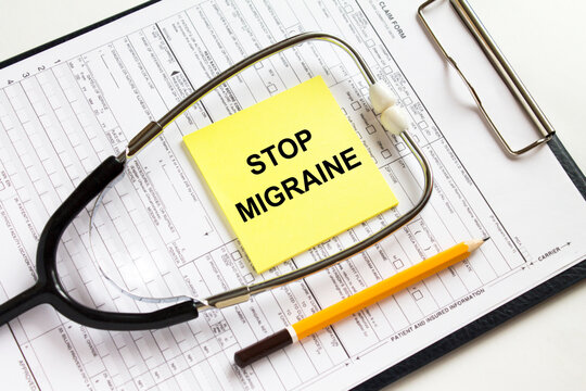 Text Stop Migraine on a yellow sticker with a stethoscope lying on a folder with medical documents