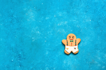 Gingerbread man on turquoise blue grunge background . Christmas baking concept. Top view, flat lay, copy space. Minimalistic Christmas composition.