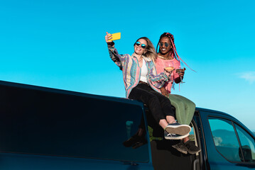 Happy multiracial friends making selfie on van roof - Focus on faces