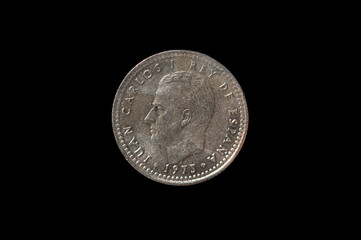 Old peseta coin with the sphinx of the Spanish King Emeritus Juan Carlos I insolated on a black...