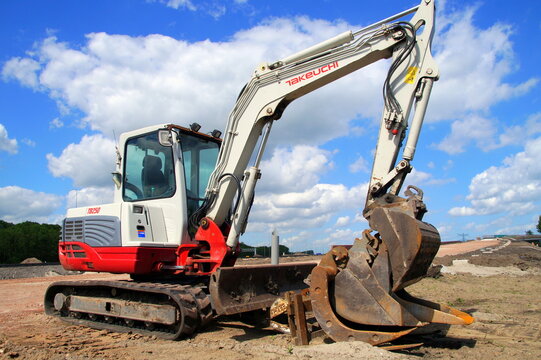 Naarden, the Netherland - July 6, 2015: Takeuchi TB250 excavator standing at a construction site against a partly clouded sky.