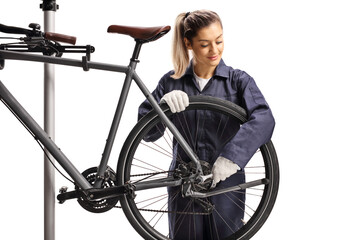 Female bike mechanic repairing a bicycle with a wrench