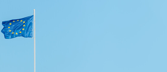 Banner with a blue with stars in circle flag of the European Union (EU) and at blue sky, with copy...