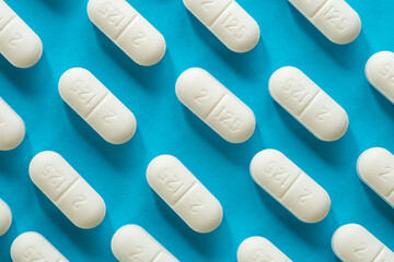 Top view of a  white rounded tablets on blue
