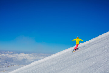 Naklejka na ściany i meble Girl snowboarder having fun in the winter ski resort.