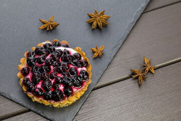 Cake with black currant and cream on a stone plate