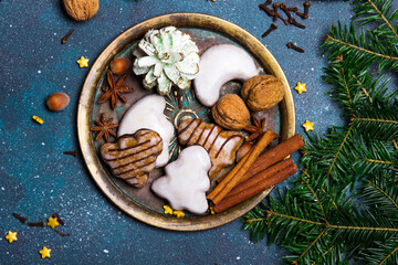 Beautiful Christmas background with decorations. Christmas cookies witch chocolate, gingerbread cookies, nuts and fir twigs on dark background. Copy space for your text