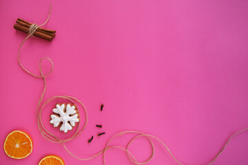 On a pink background, New Year's gingerbread, orange, cinnamon.
Composition with empty space for text.
Top view, flat lay.