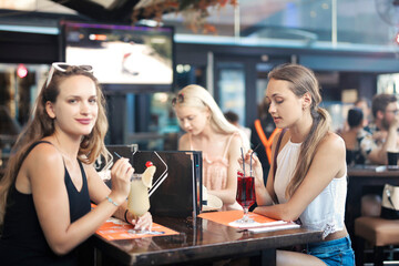 
group of girlfriends drink in a bar